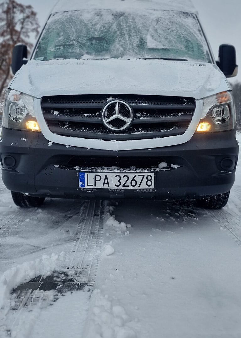 Ośnieżony, biały bus marki Mercedes