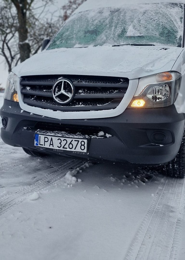 Ośnieżony, biały bus marki Mercedes